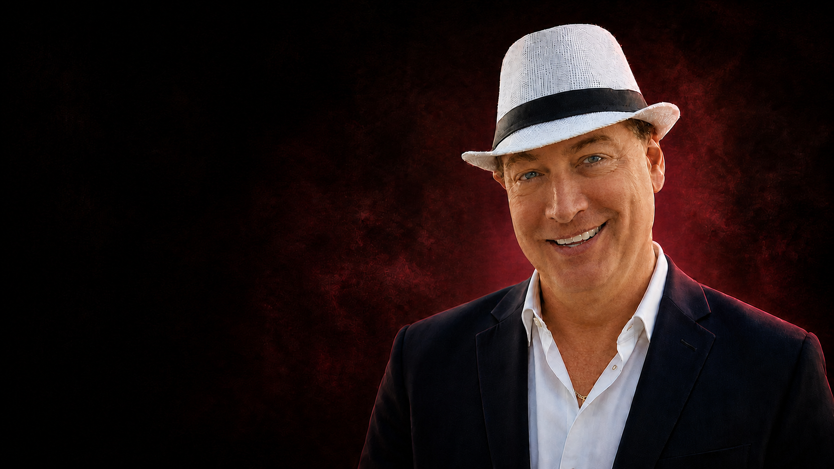 Cinematic portrait of Barry Henthorn in a navy suit and white hat